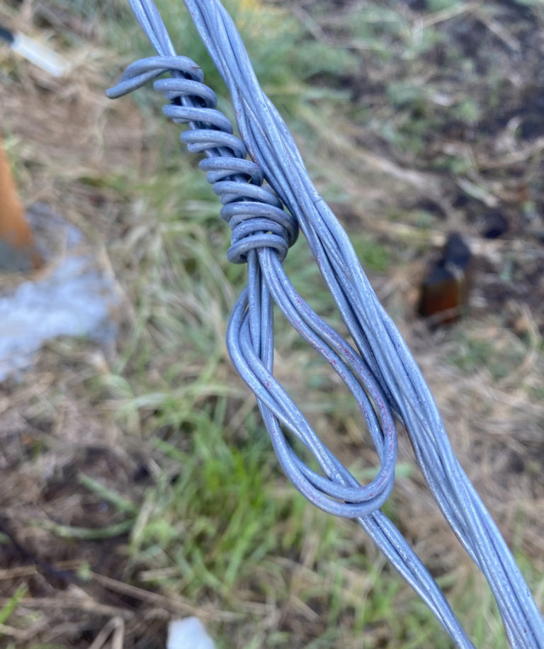 A strainer knot tied in double-strand slick wire on a fence H-brace
